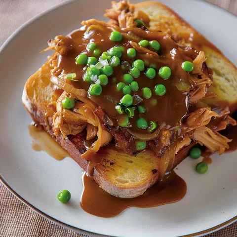Un sandwich de canard garni de sauce et légumes pour un repas gourmand.
