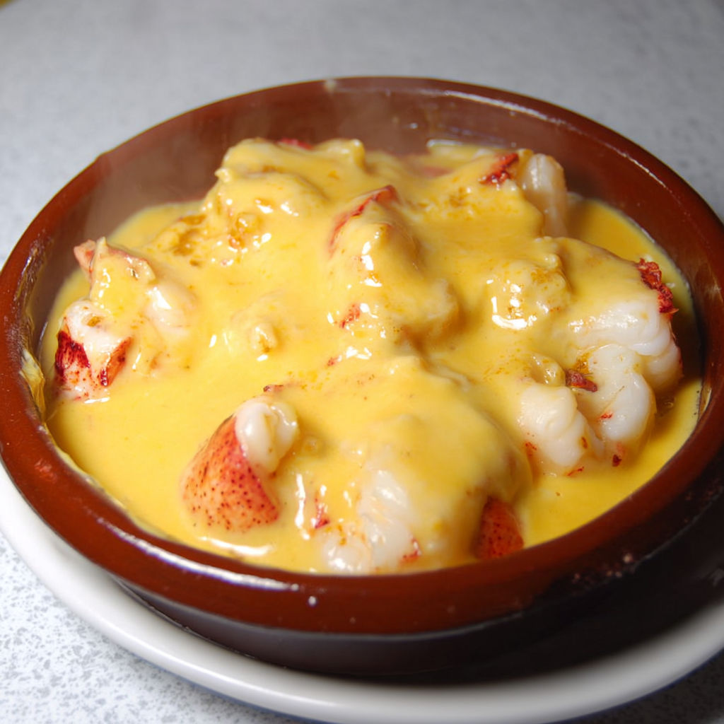Plat en terre cuite avec homard et crème chaude safranée.