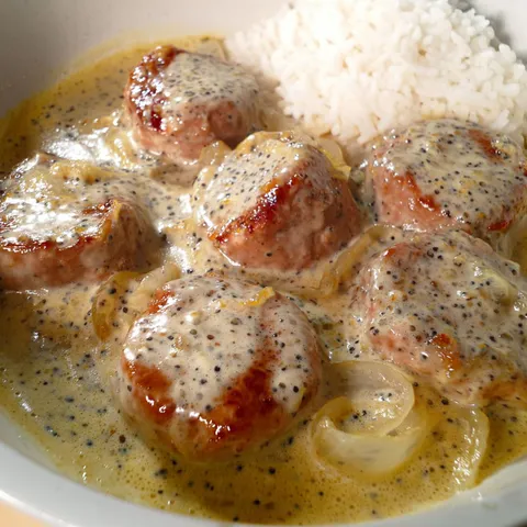 Un plat de porc crémeux présenté dans un bol avec des condiments.