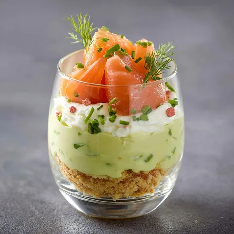 Un petit verre rempli d’une mousse d’avocat et de saumon.
