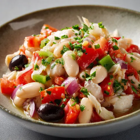 Bol de légumes frais, tomates, olives et herbes méditerranéennes.