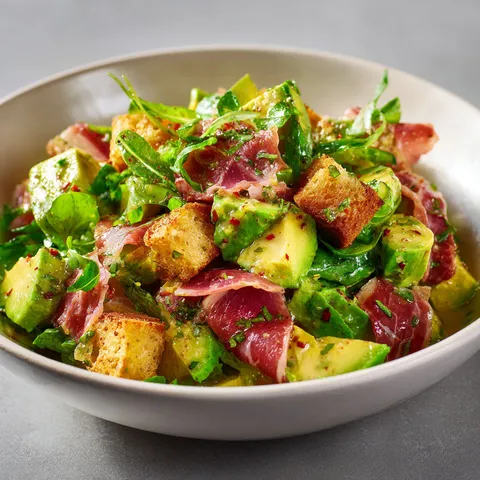 Un bol de salade avec avocat et jambon, plein de fraîcheur.