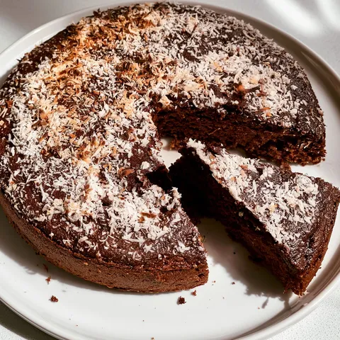 Part de gâteau choco-coco décorée de noix de coco.