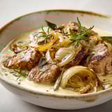 Filet mignon de porc servi avec oignons caramélisés, herbes fraîches et sauce parfumée.