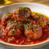 Sur une belle assiette rustique, des boulettes appétissantes préparées par Cyril Lignac.