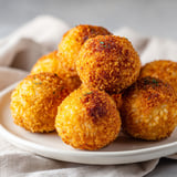 Boulettes croustillantes, dorées, garnies de mozzarella fondante et prêtes à être servies.