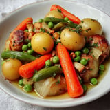 Jeunes légumes printaniers comme des carottes, pois, asperges, présentés dans une assiette colorée.