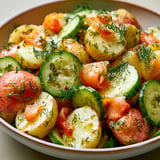 Un bol de salade composée avec pommes de terre et truite fumée.